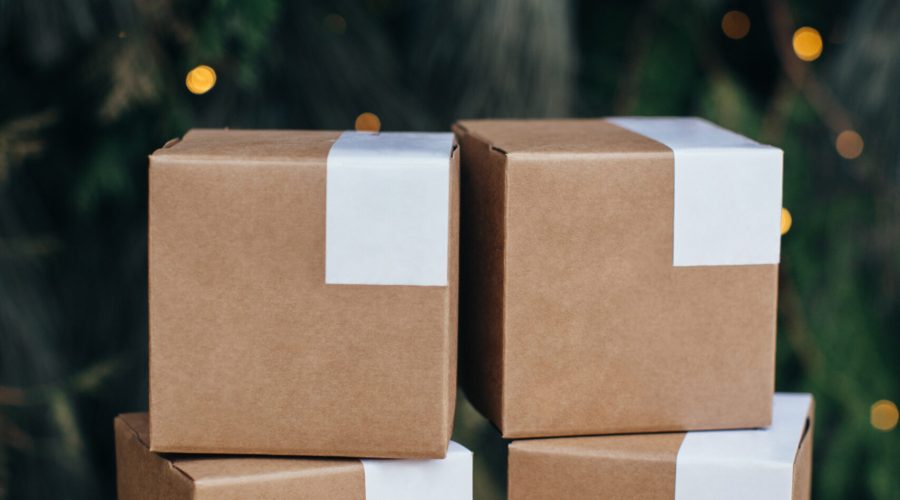 Mockup. Kraft paper boxes with white stickers on Christmas background.